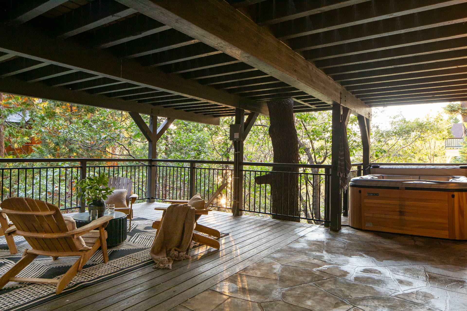 Lower deck with cedar-framed hot tub beneath the trees